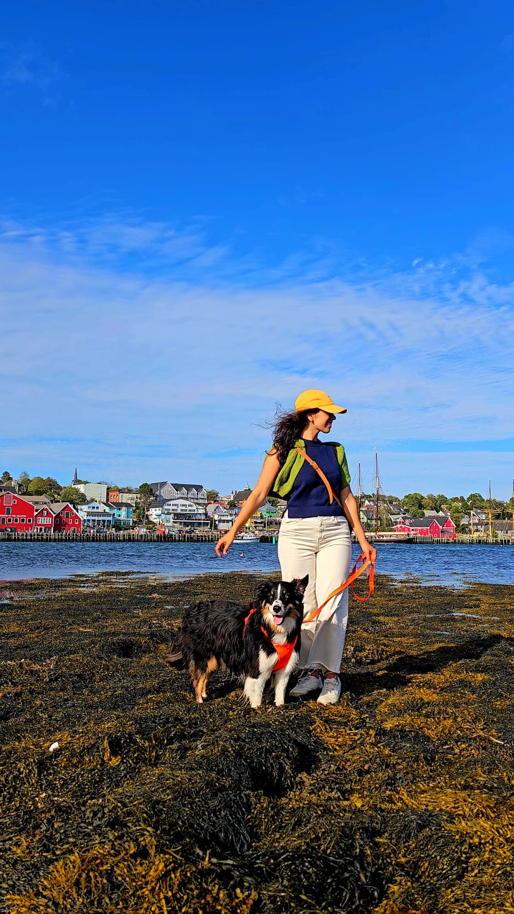 Sarah outdoors by the Nova Scotia waterfront with her dog.
